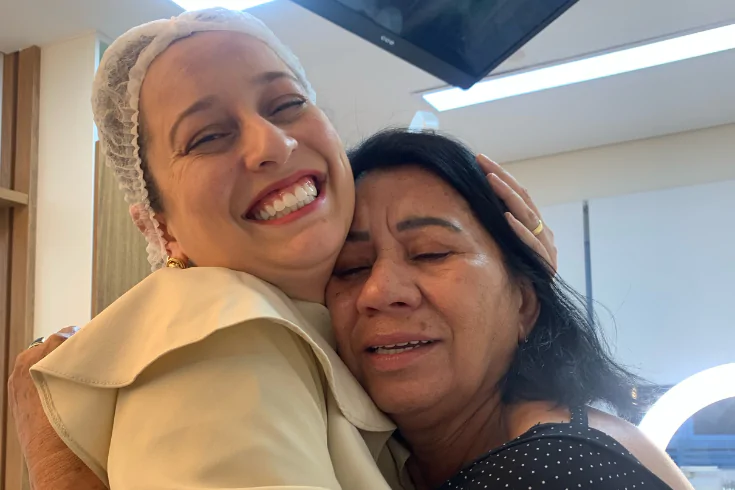 Doutora abraçando uma paciente na clínica